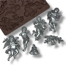 Decorative silver cherub figurines next to a silicone mold on a white background.