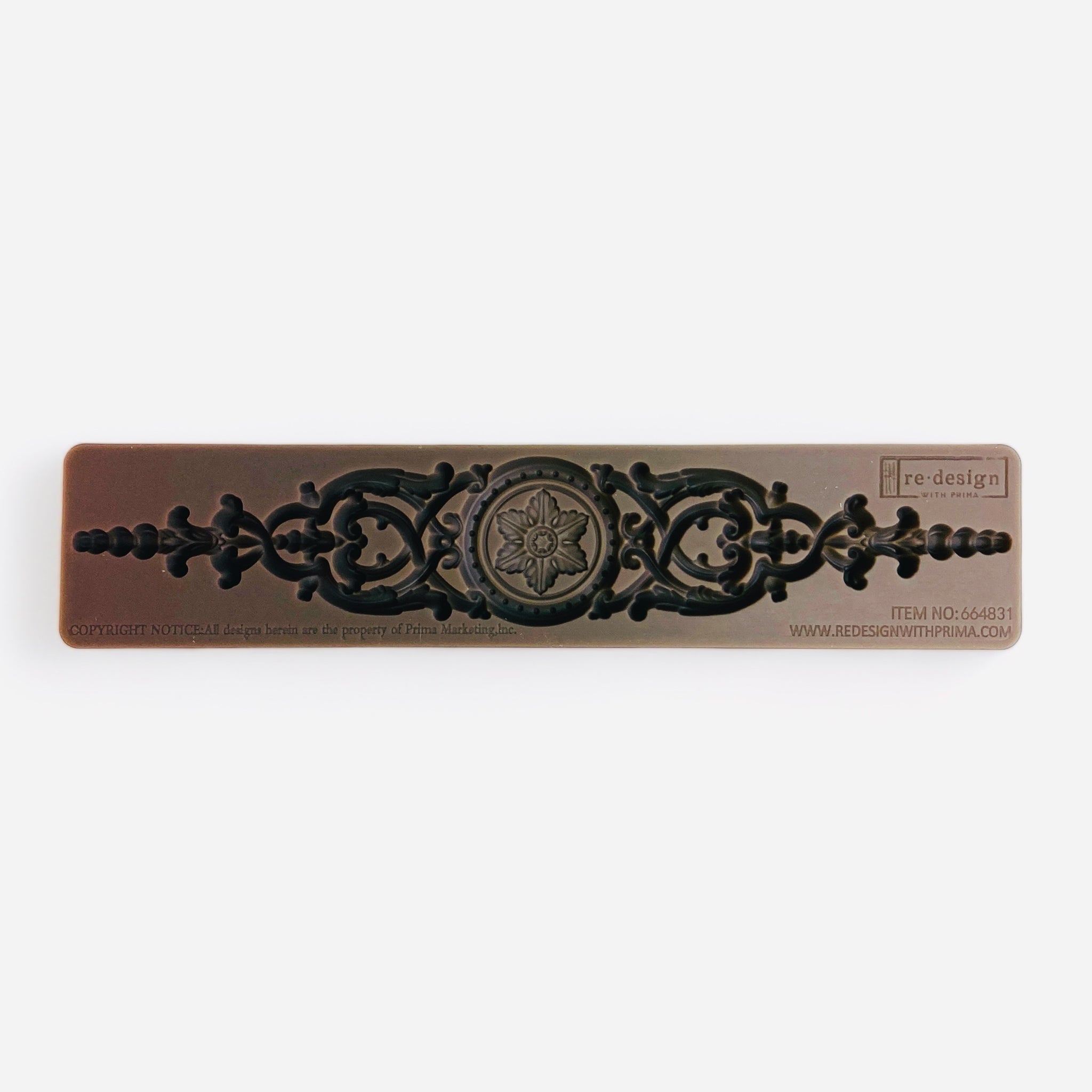 A brown silicone mold of a long ornate medallion with a round floral center detail is against a white background.