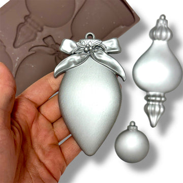 Silver Christmas ornament held in a hand with blurred mold in the background