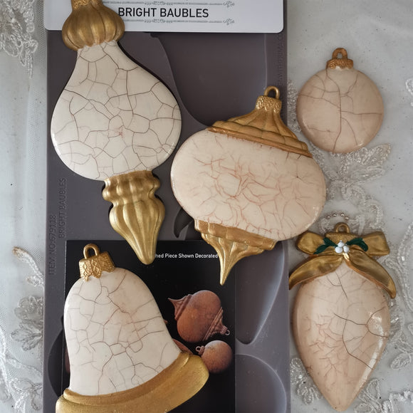 Decorative baubles with cracked texture and gold accents on a gray background