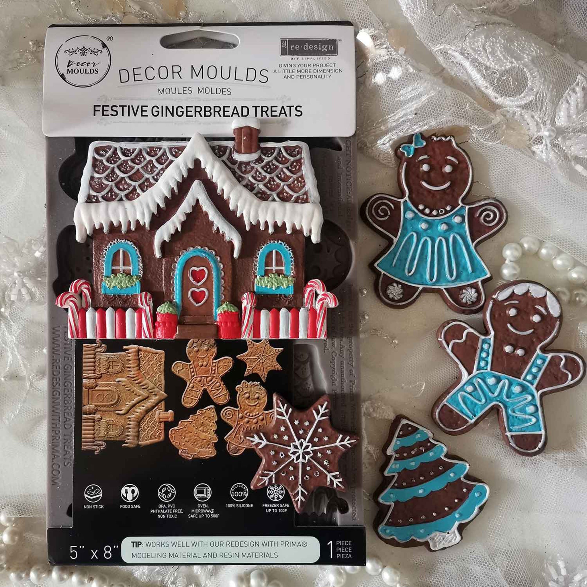 A package of ReDesign with Prima's Festive Gingerbread Treats silicone mold and colorful castings created by Casamia are against a white Sherpa blanket background.