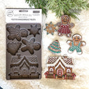 A package of ReDesign with Prima's Festive Gingerbread Treats silicone mold and colorful castings created by Casamia are against a white Sherpa blanket background.
