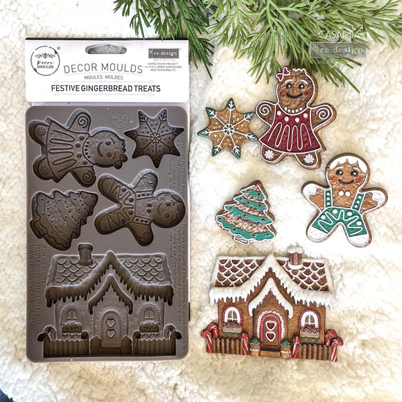 A package of ReDesign with Prima's Festive Gingerbread Treats silicone mold and colorful castings created by Casamia are against a white Sherpa blanket background.