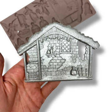 silver manger held by a hand with a white background