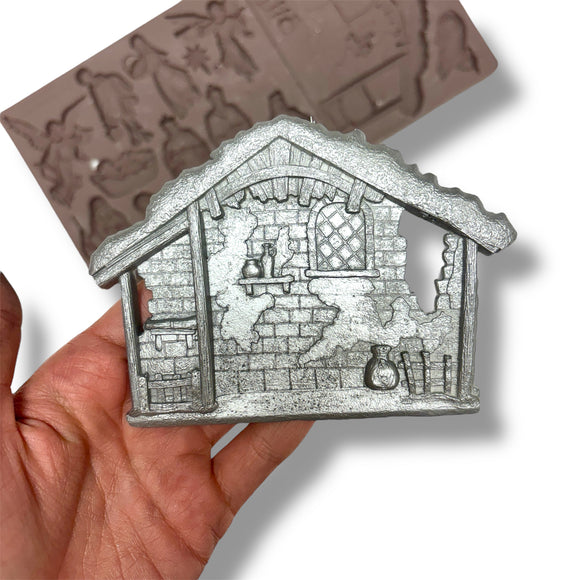 silver manger held by a hand with a white background