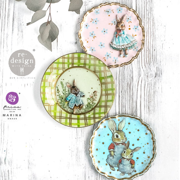 Three decorative plates with rabbit illustrations on a white wooden surface.