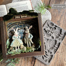 Decorative box with rabbit figures and a mold on a wooden surface