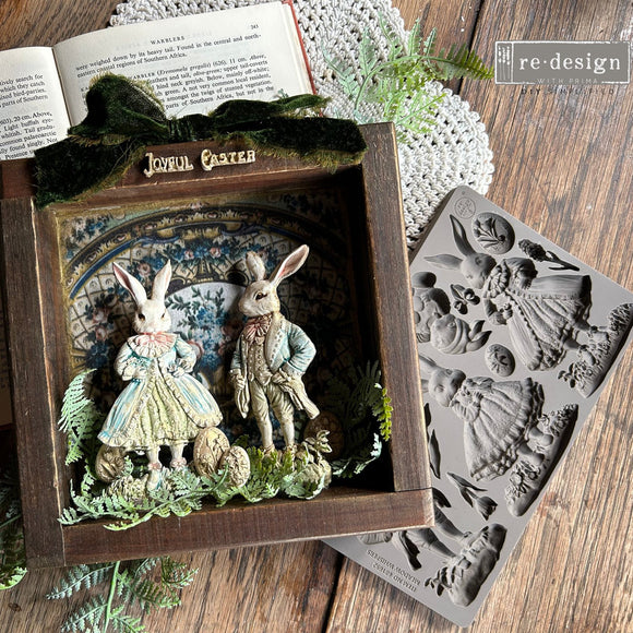 Decorative box with rabbit figures and a mold on a wooden surface
