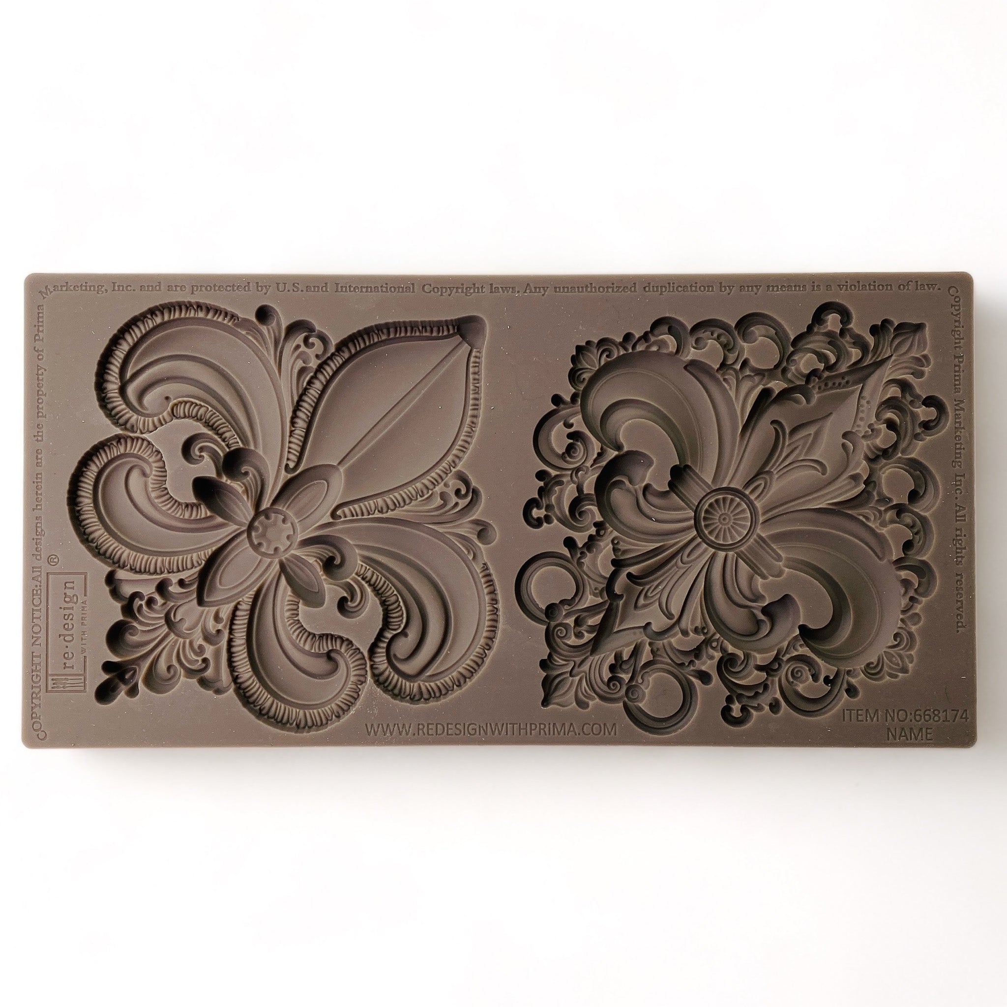 A brown silicone mold of 2 large ornate Fleur de Lis designs is against a white background.