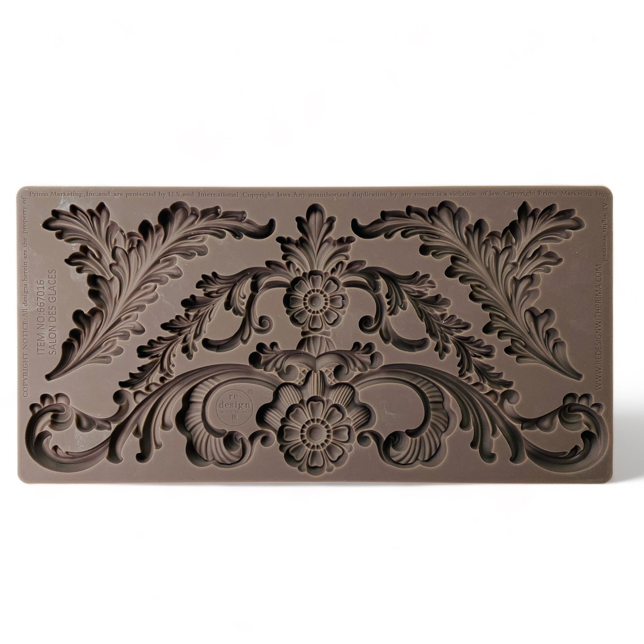 A brown silicone mold of a large ornate scroll floral leaf accent piece and 2 leaf plumes is against a white background.