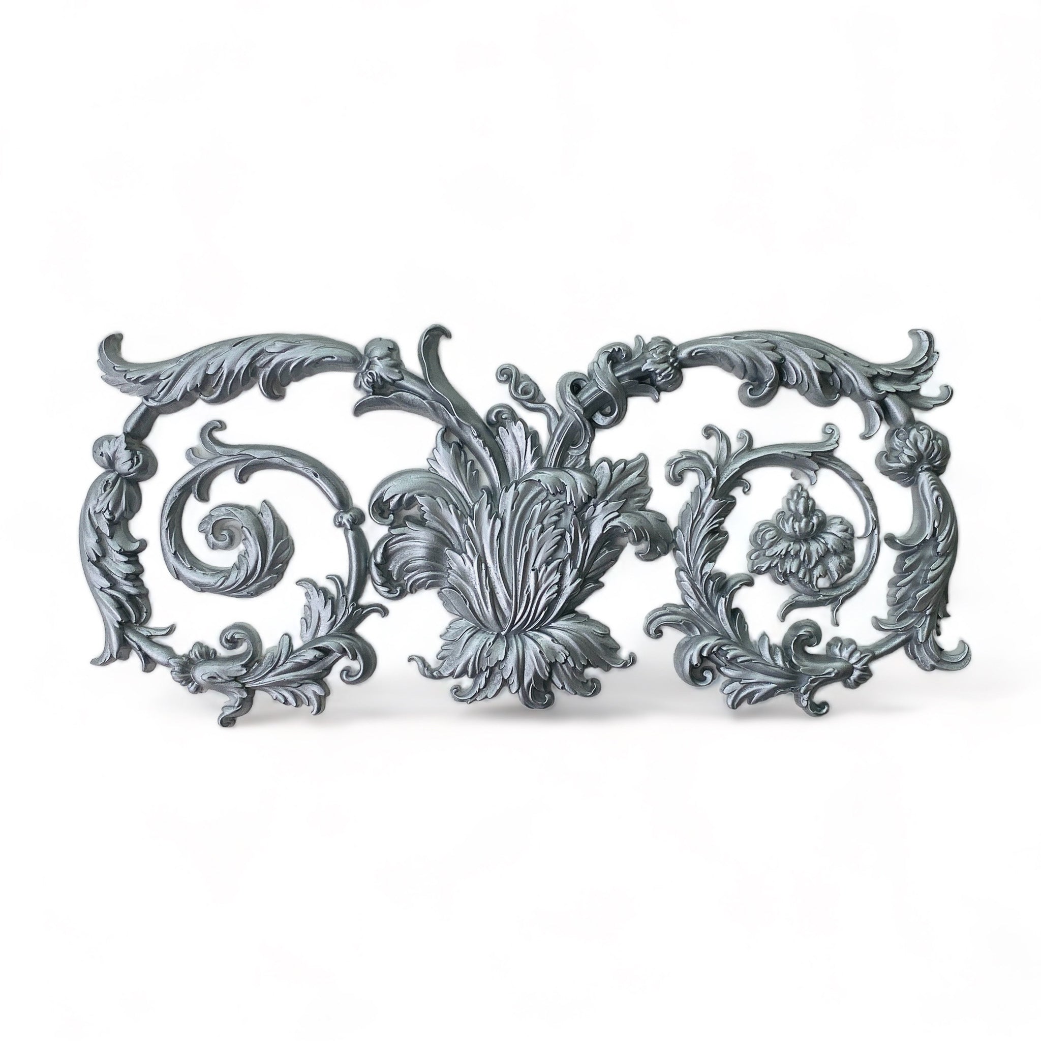 A silver-colored silicone mold casting of a large ornate curling scroll leaf accent piece is against a white background.