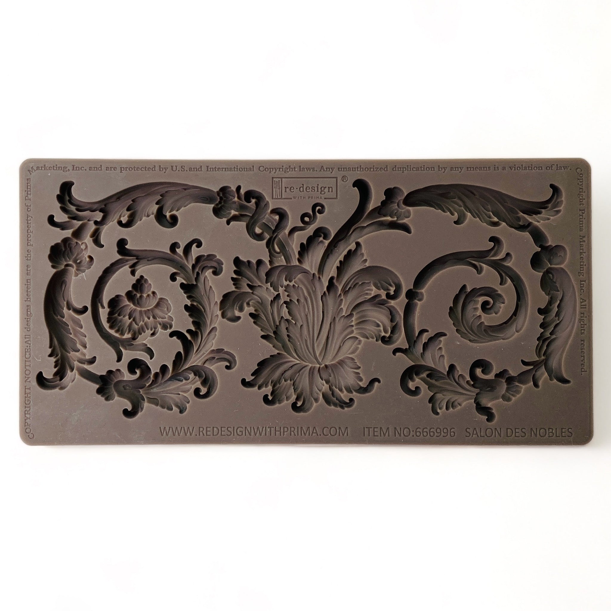 A brown silicone mold of a large ornate curling scroll leaf accent piece is against a white background.