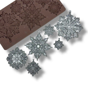 Decorative snowflake mold and finished snowflakes on a white background