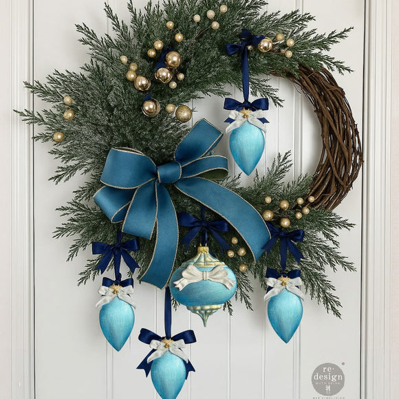 Evergreen door wreath with a large teal bow and blue ornaments with small bow details—festive bow decor inspiration for Timeless Ties.
