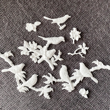 White bird and branch castings from the Whispers of Wings 5x8 silicone mold on gray fabric