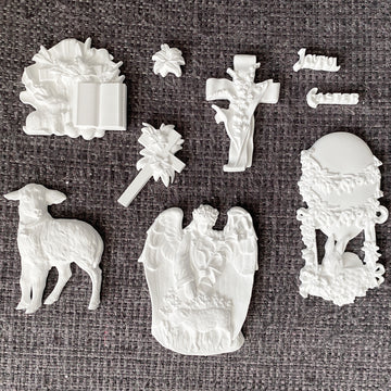 White resin castings from Eternal Spring Faith mold including lamb, angel scene, cross with lilies, floral egg frame, Bible and Joyful Easter words