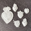 White resin castings from ReDesign with Prima The Love Edit sacred heart silicone mold on gray fabric