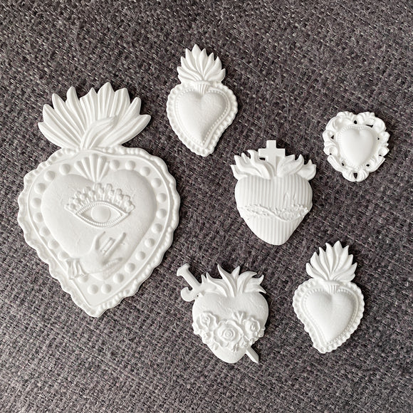 White resin castings from ReDesign with Prima The Love Edit sacred heart silicone mold on gray fabric