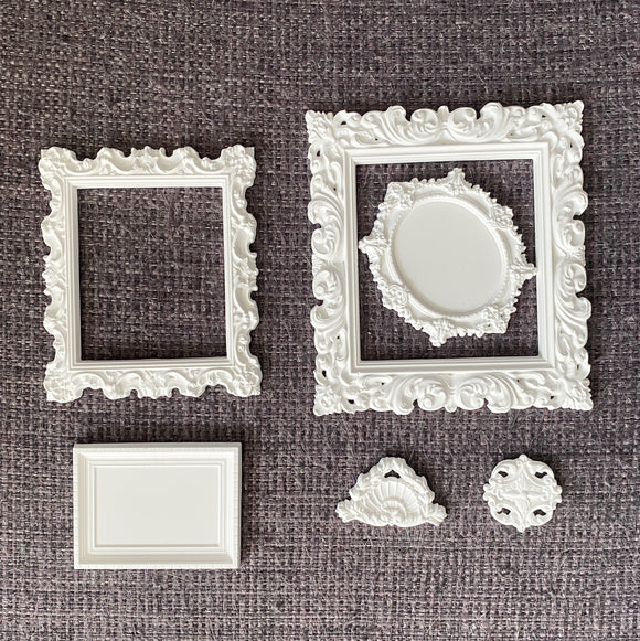 Miniature Grace Frames silicone mold castings—white ornate square and oval vintage frames with crest and medallion embellishments