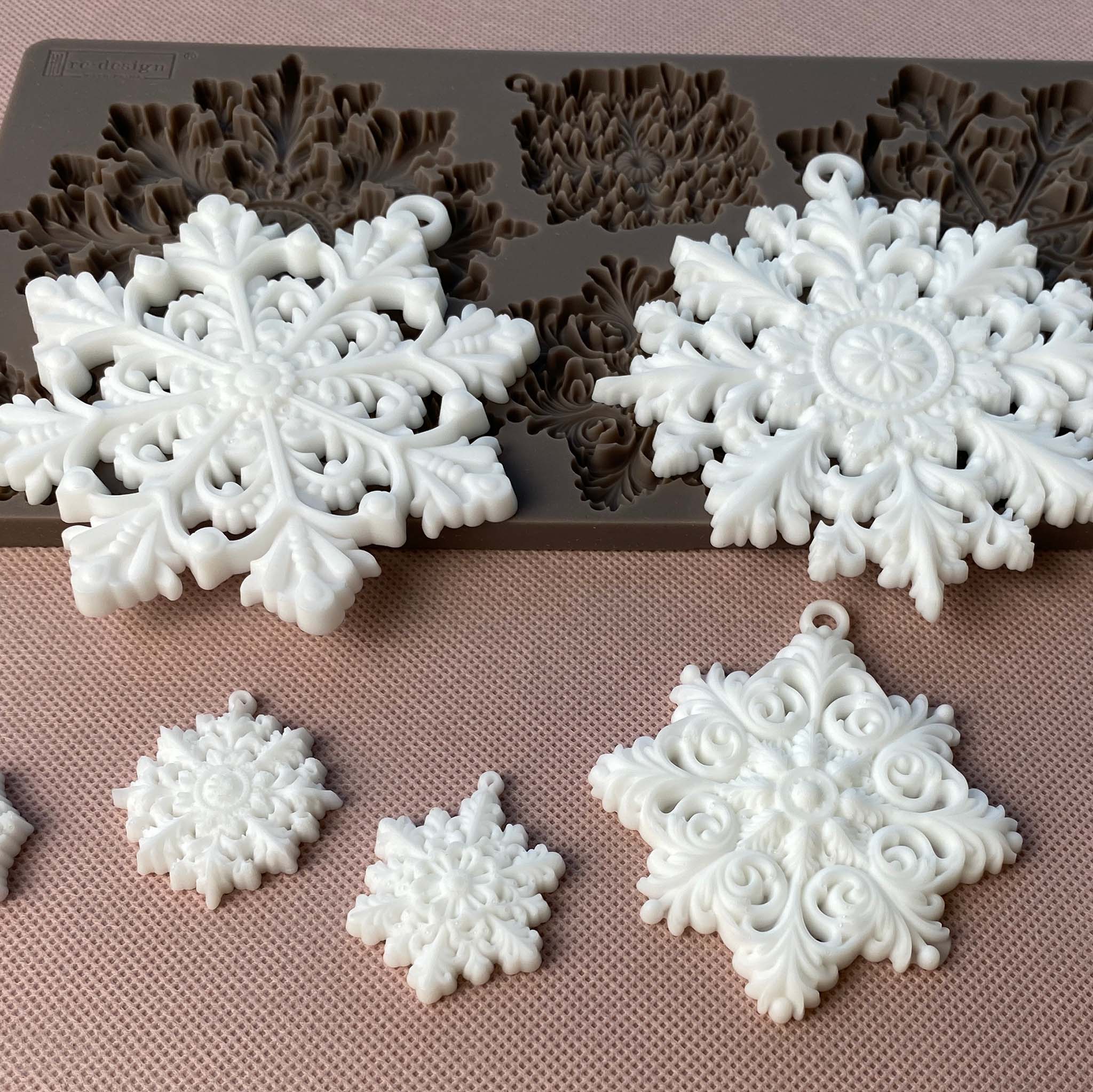 White resin castings of ReDesign with Prima's Frost Spark are set on top and under their brown silicone mould.
