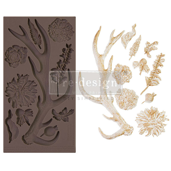 A brown silicone mould and gold/white castings of an antler and 9 flower and foliage pieces are against a white background.