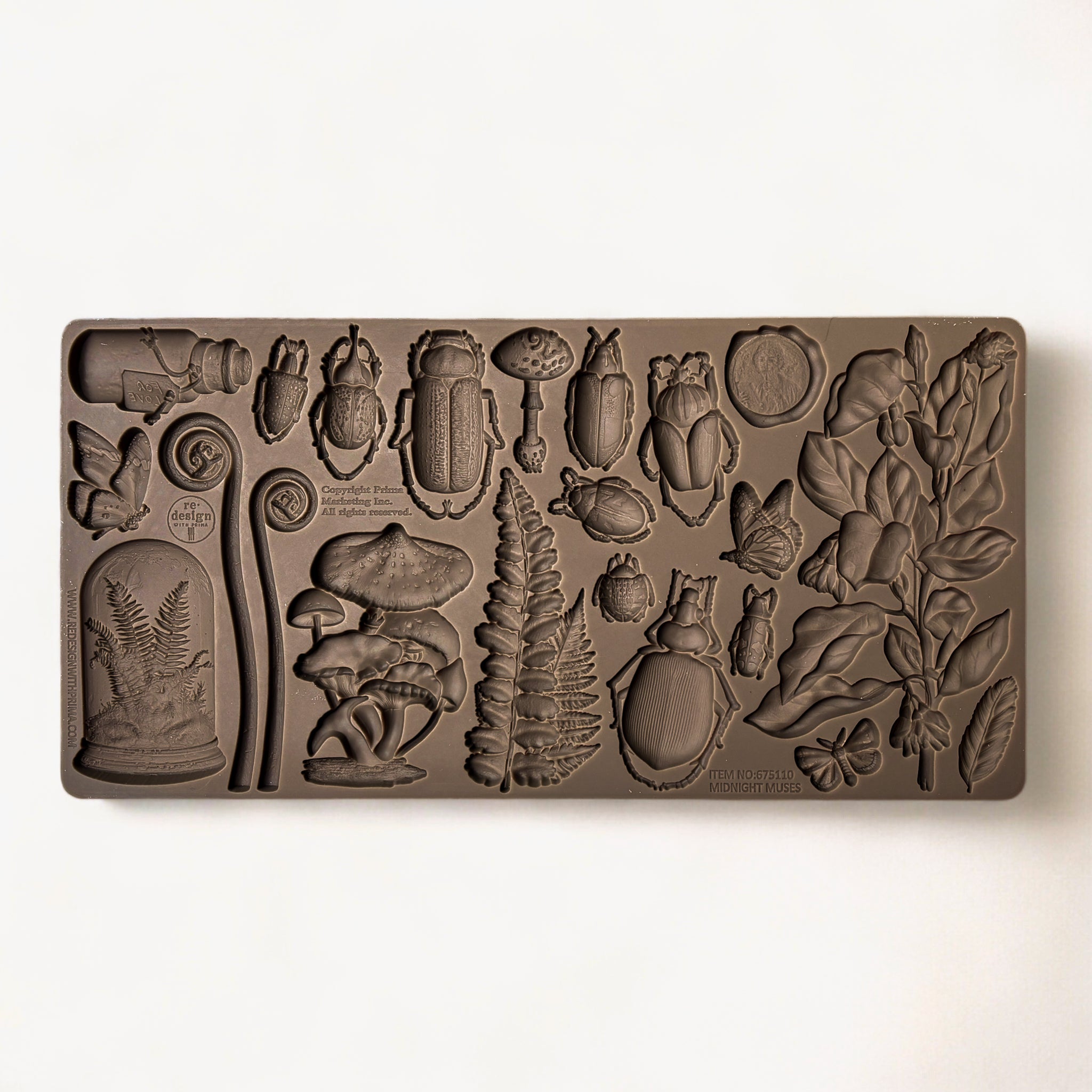 A brown silicone mold featuring ferns, insects, mushrooms, and vintage glass containers is against a white background.