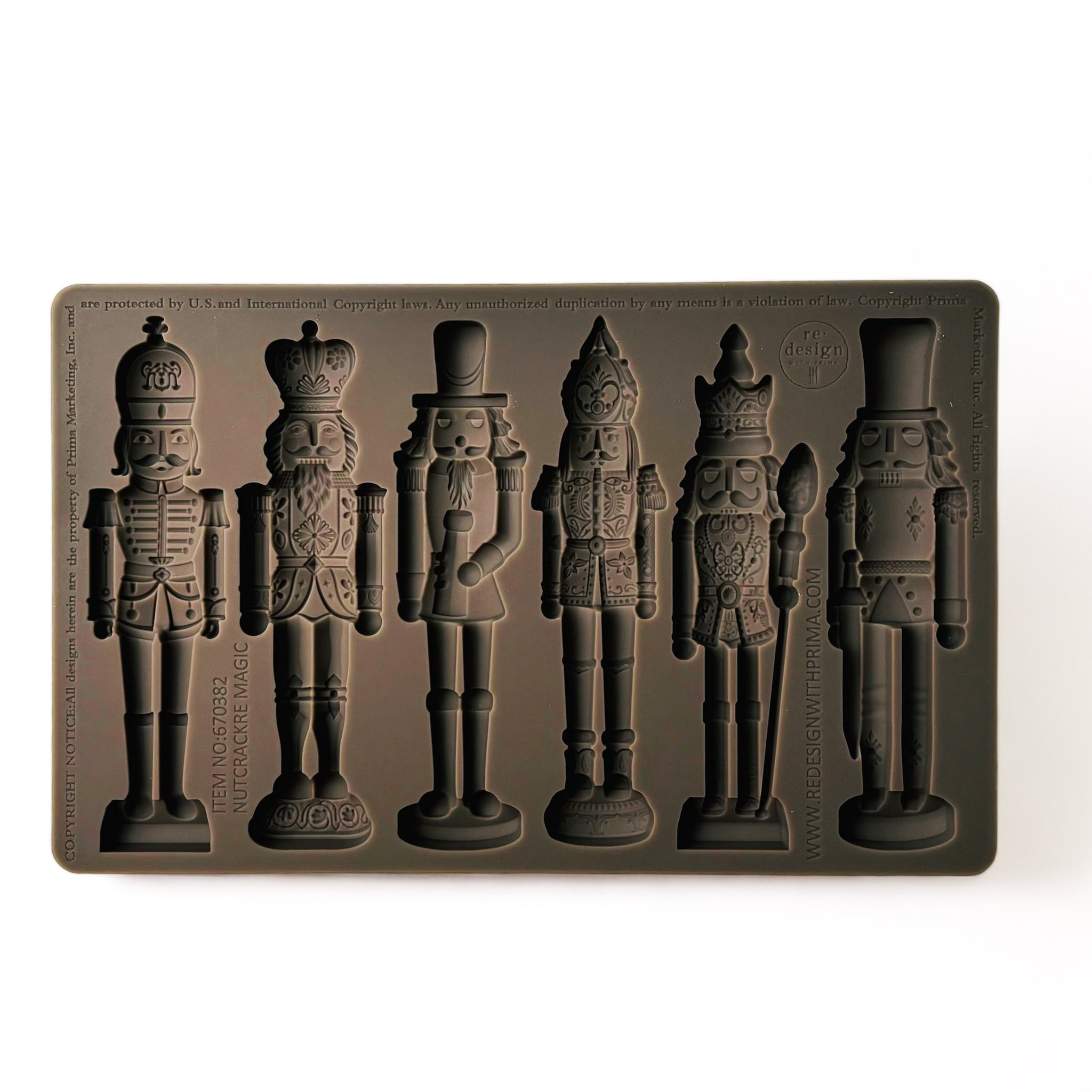 A brown silicone mold that features 6 ornately decorated nutcrackers is against a white background.