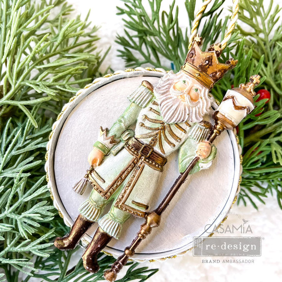 A round flat ornament created by Casamia features a painted casting of a king from ReDesign with Prima's Nutcracker Party silicone mold.