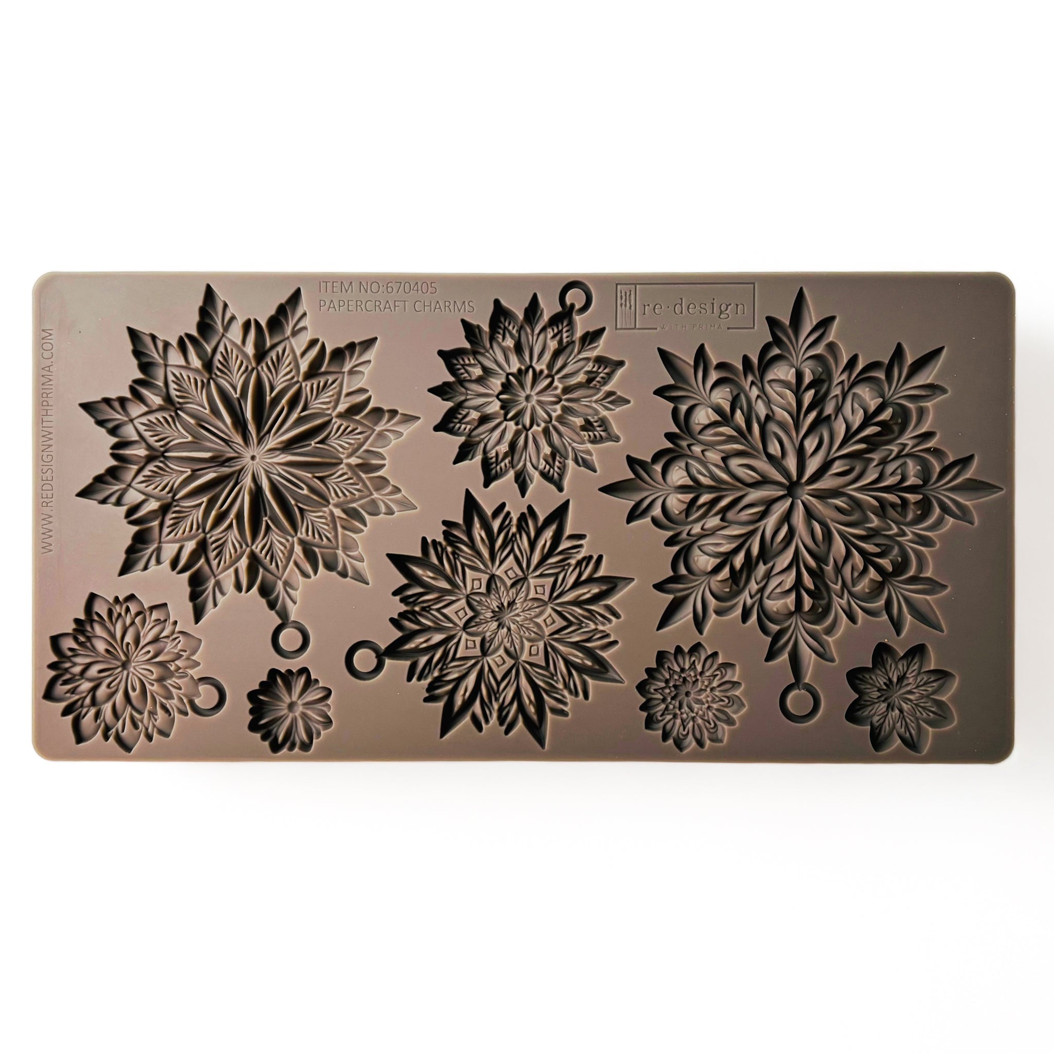 A brown silicone mold of 3 large, and 5 smaller ornate snowflakes is against a white background.