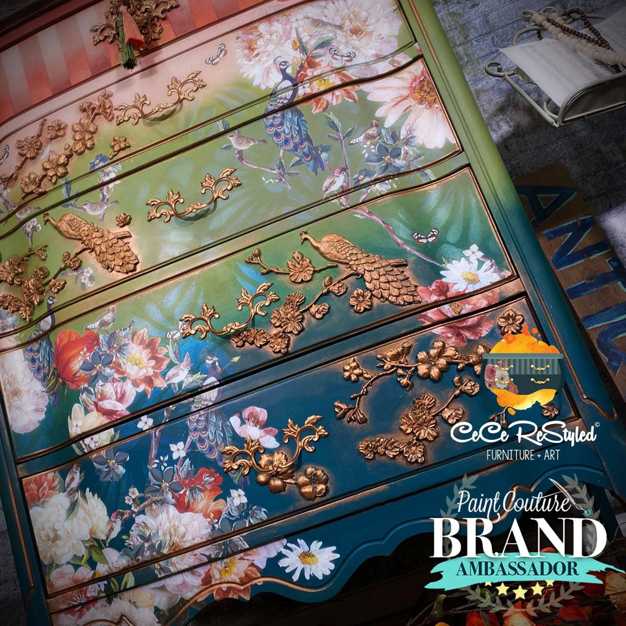 A 5-drwer chest dresser refurbished by CeCe Restyled is painted a blend of salmon, spring green, and blue features bronze colored castings made from ReDesign with Prima's Regal Peacock silicone mold.