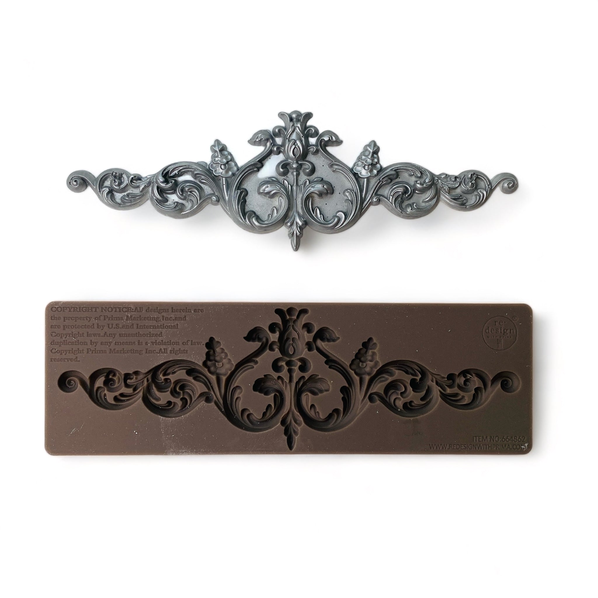 A brown silicone mold and silver colored casting of an ornate scroll design are against a white background.