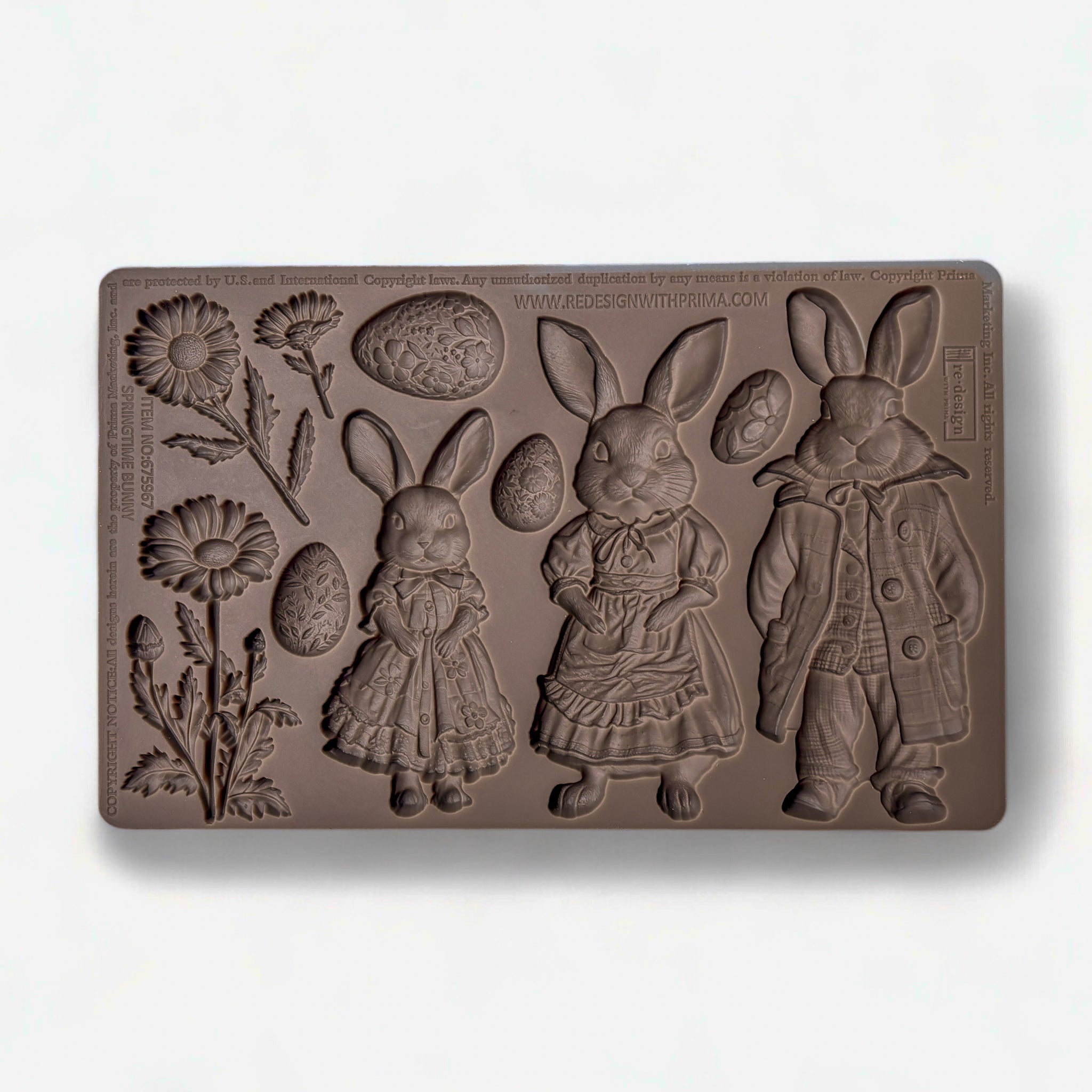 A brown silicone mold featuring 3 cute bunnies in clothes, 3 flowers, and 4 Easter eggs is against a white background.