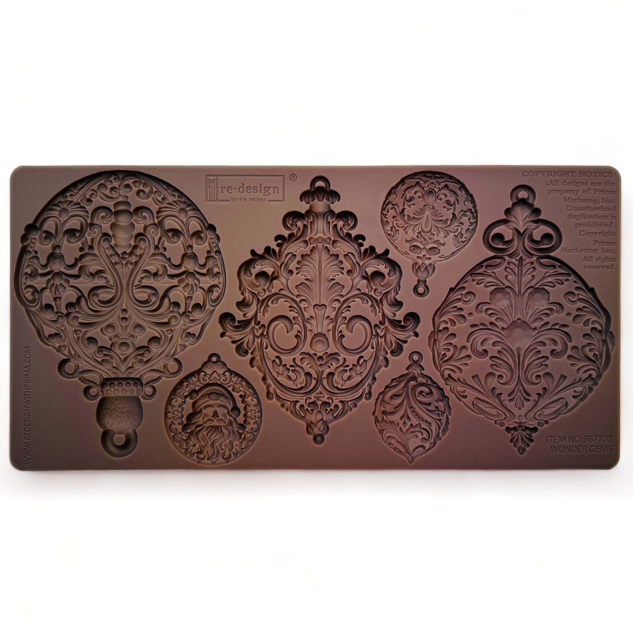 A brown silicone mold of 6 varying size ornately decorated tree ornaments is against a white background.