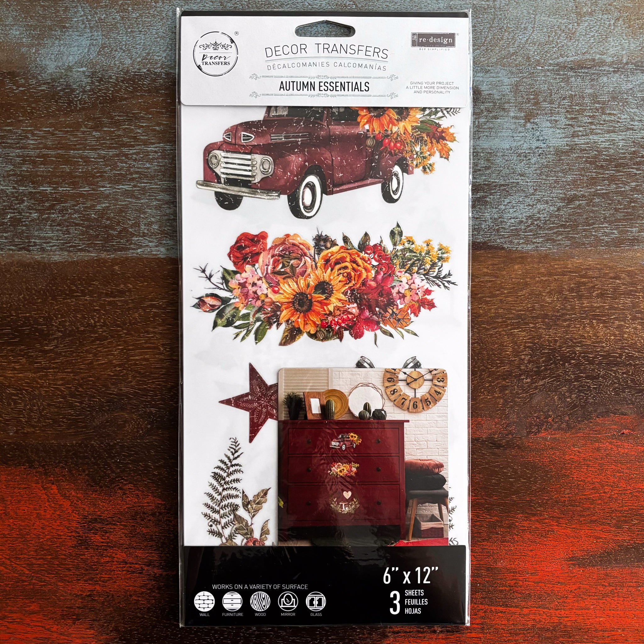 A package of ReDesign with Prima's Autumn Essentials small transfer is against a dark wood background.