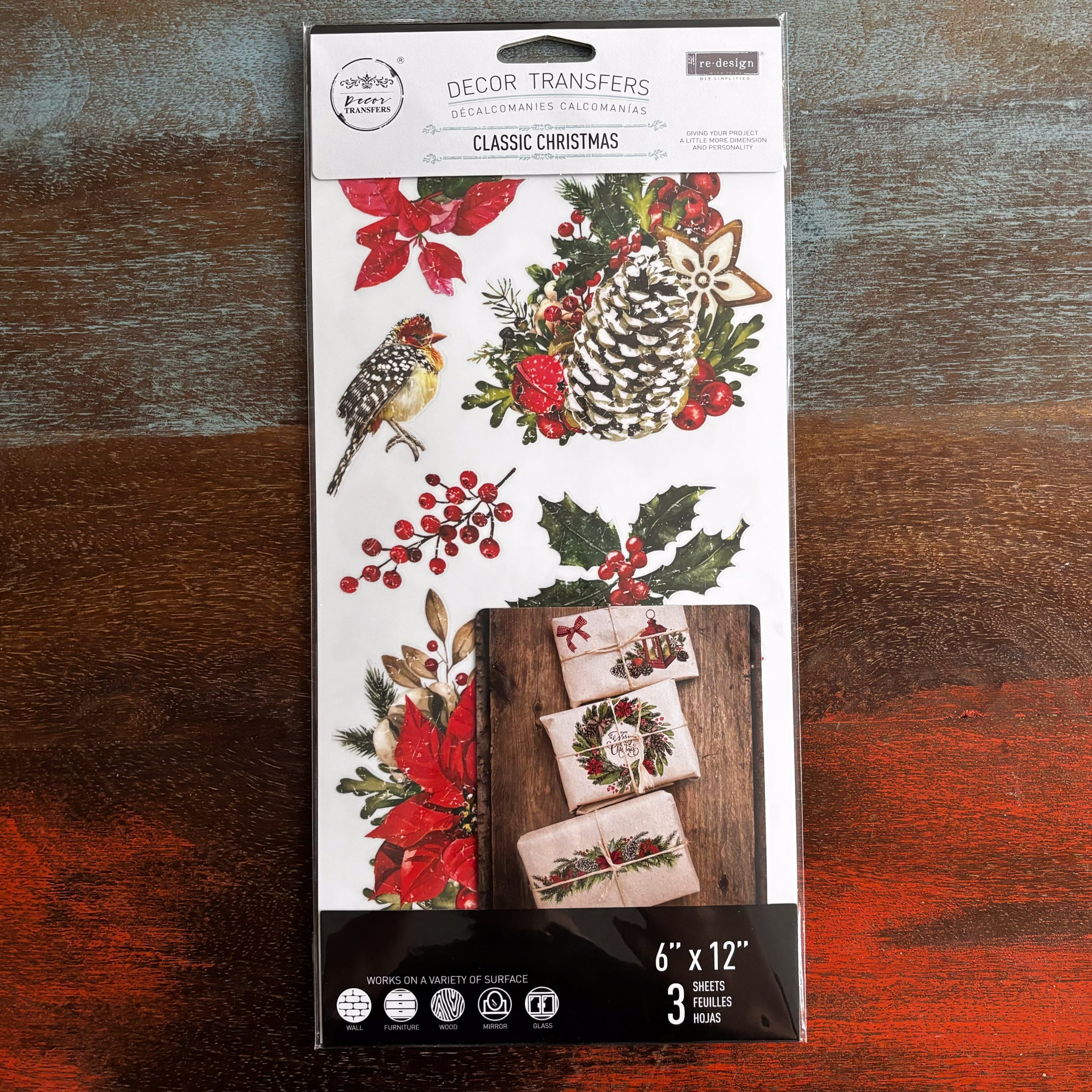 A package of ReDesign with Prima's Classic Christmas small transfer is against a dark wood background.