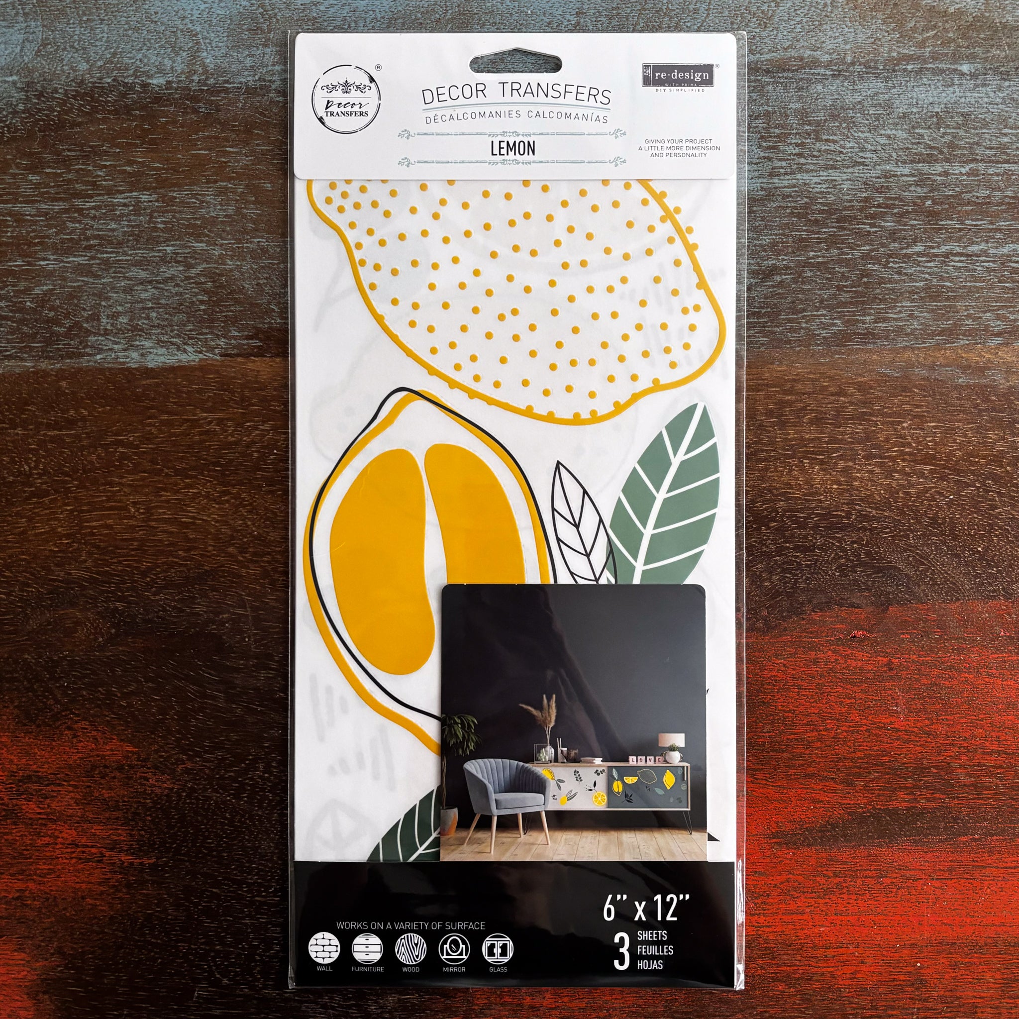 A package of ReDesign with Prima's Lemon small transfer is against a dark wood background.