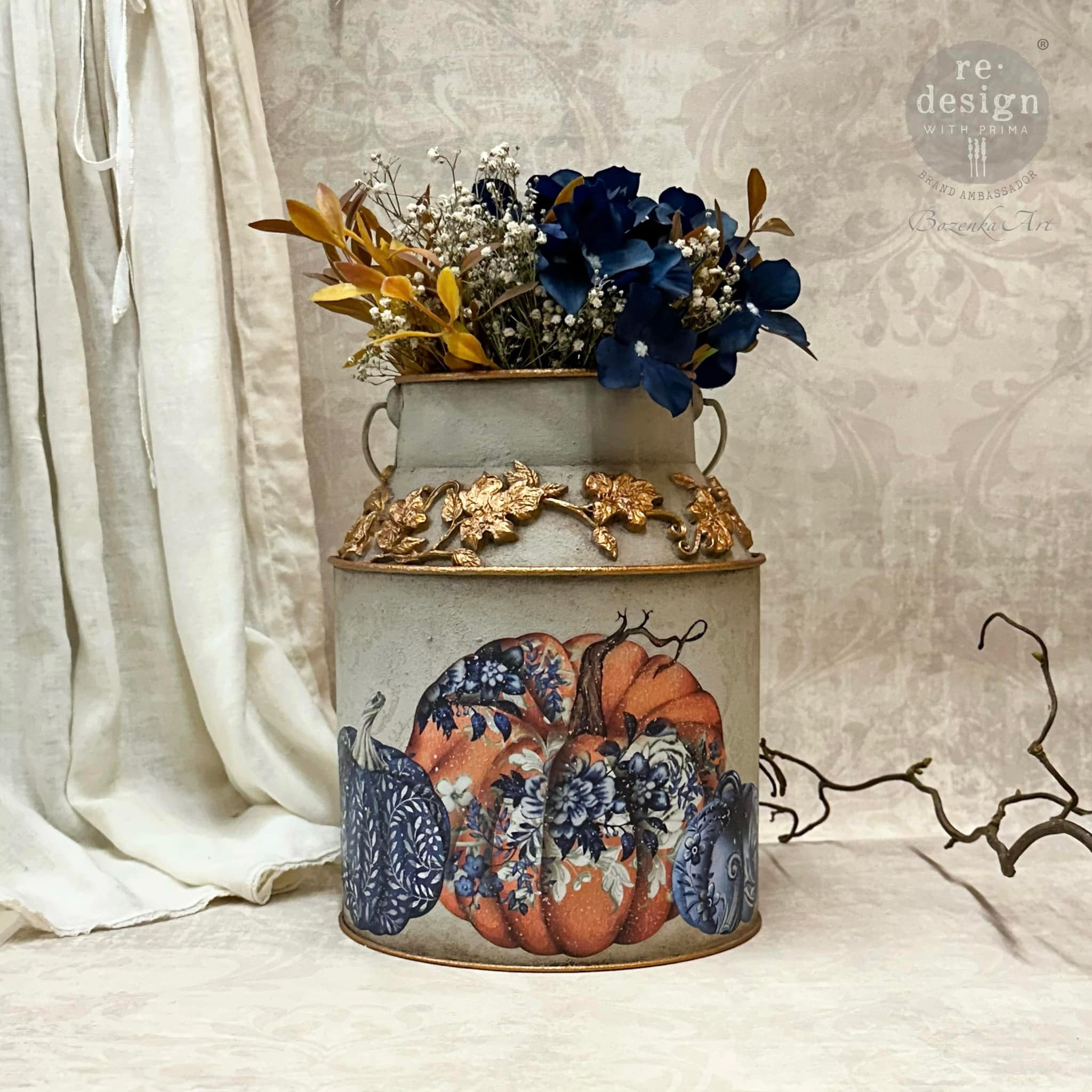 A vintage metal milk can refurbished by Bozenka Art is painted grey with gold accents and features ReDesign with Prima's Pumpkin Patch Galore small transfer on it.