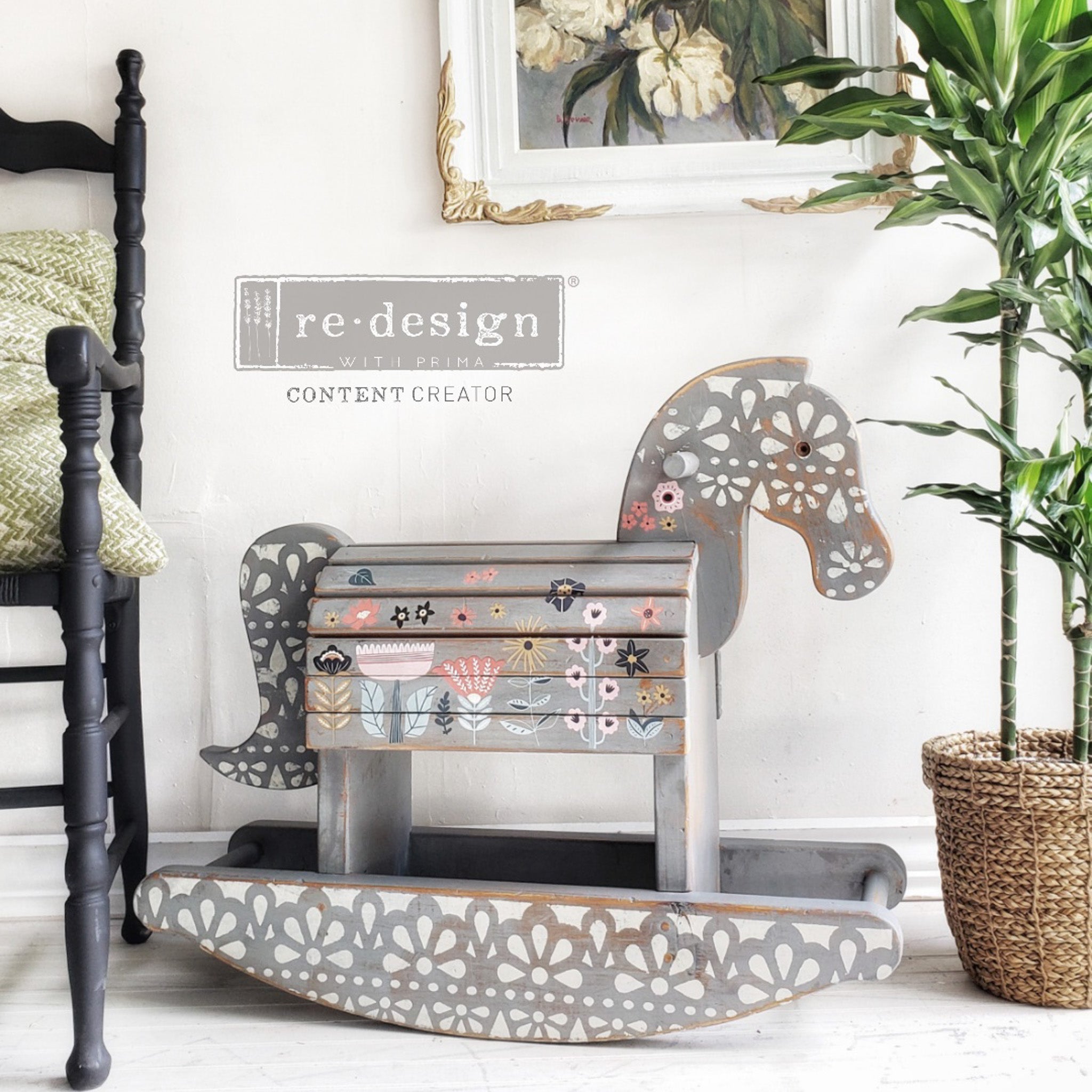 A vintage wood rocking horse ispainted light gray with white stenciling and features ReDesign with Prima's Doodle Flowers small rub-on transfers on it.