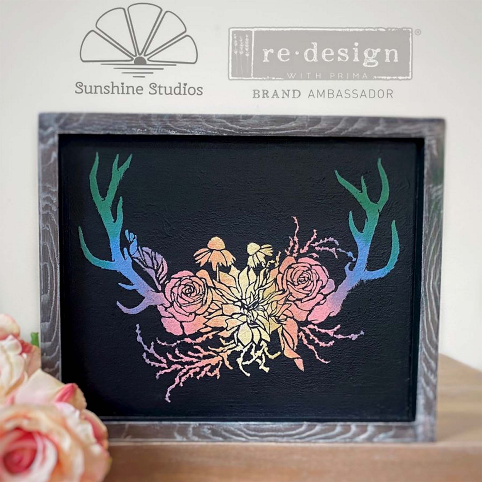 A wood photo frame refurbished by Sunshine Studios is gray washed on the frame and black inside the frame. Against the black is amn ombre pastel colorful blend of ReDesign with Prima's Wildwood Cabin 3D stencil design.