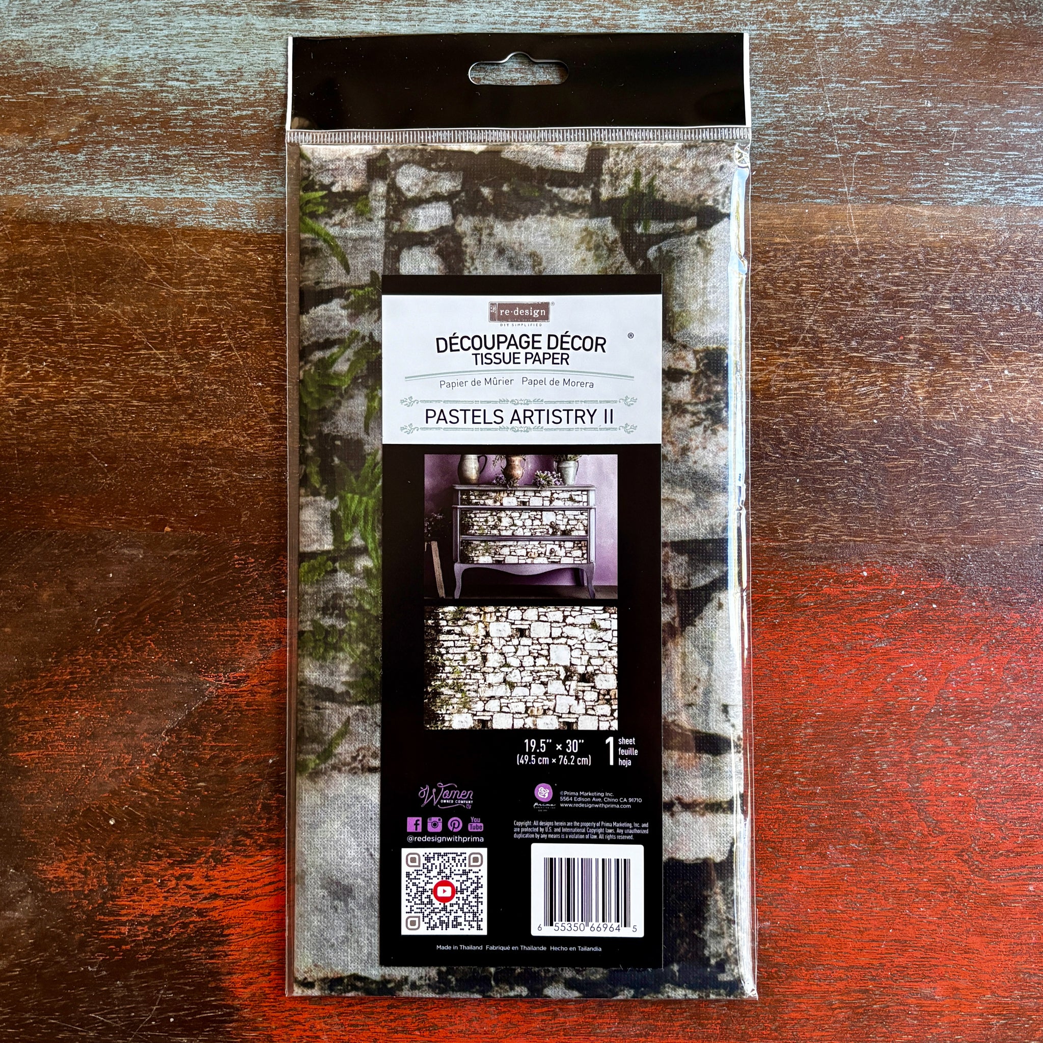 A package of ReDesign with Prima's Pastels Artistry 2 tissue paper is against a dark wood background.