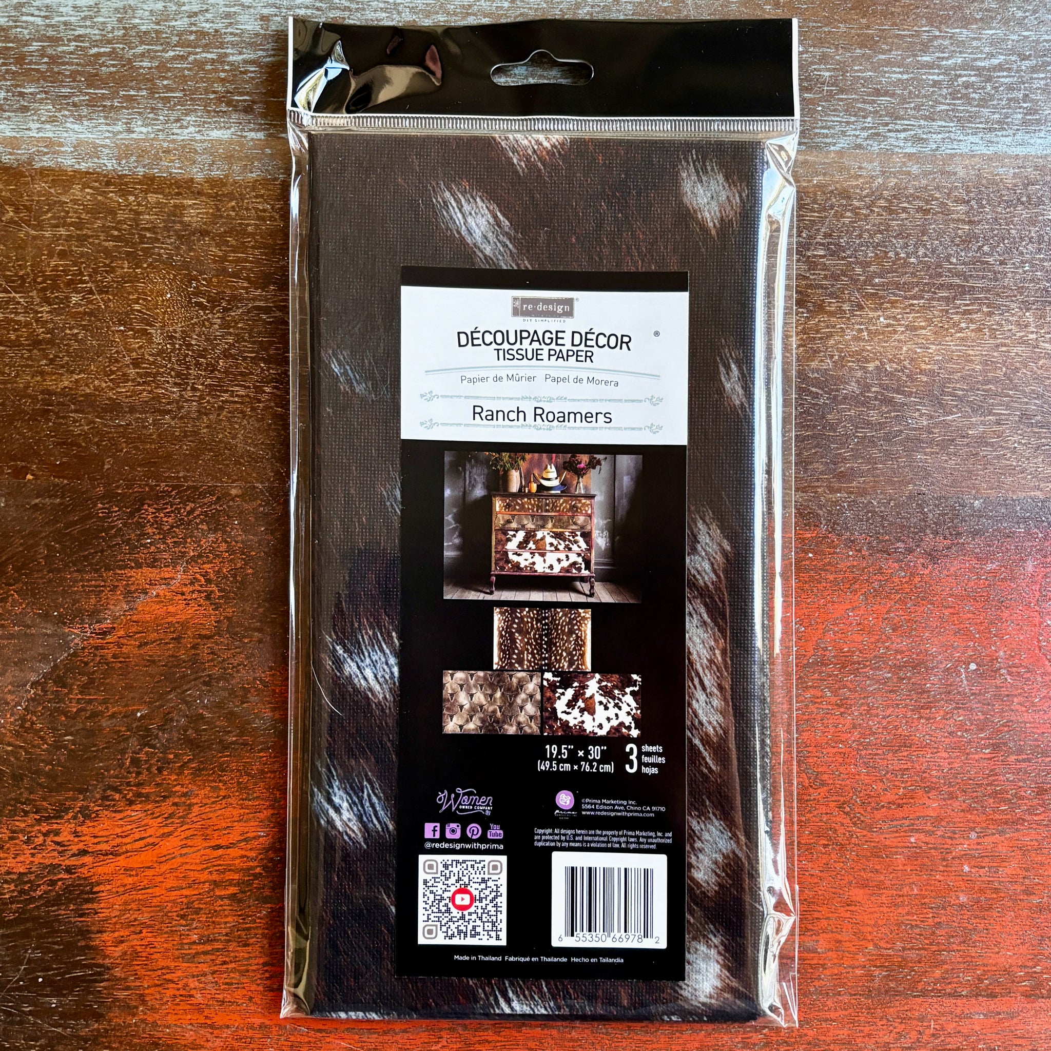 A package of ReDesign with Prima's Ranch Roamers tissue paper is against a dark wood background.