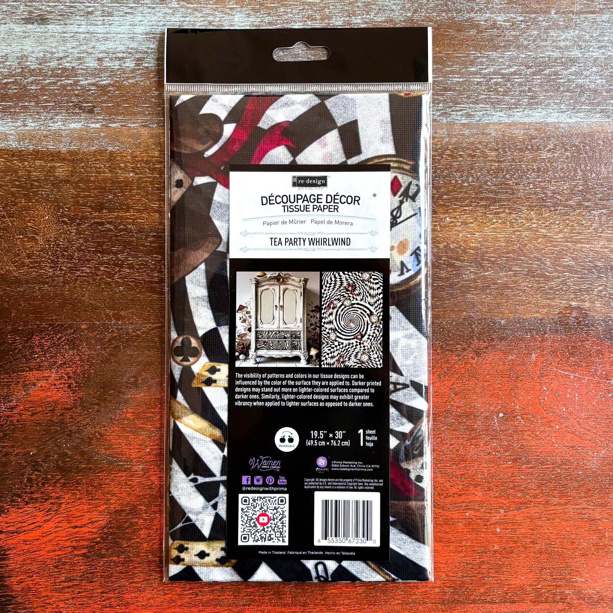 A package of ReDesign with Prima's Tea Party Whirlwind tissue paper is against a dark wood background.