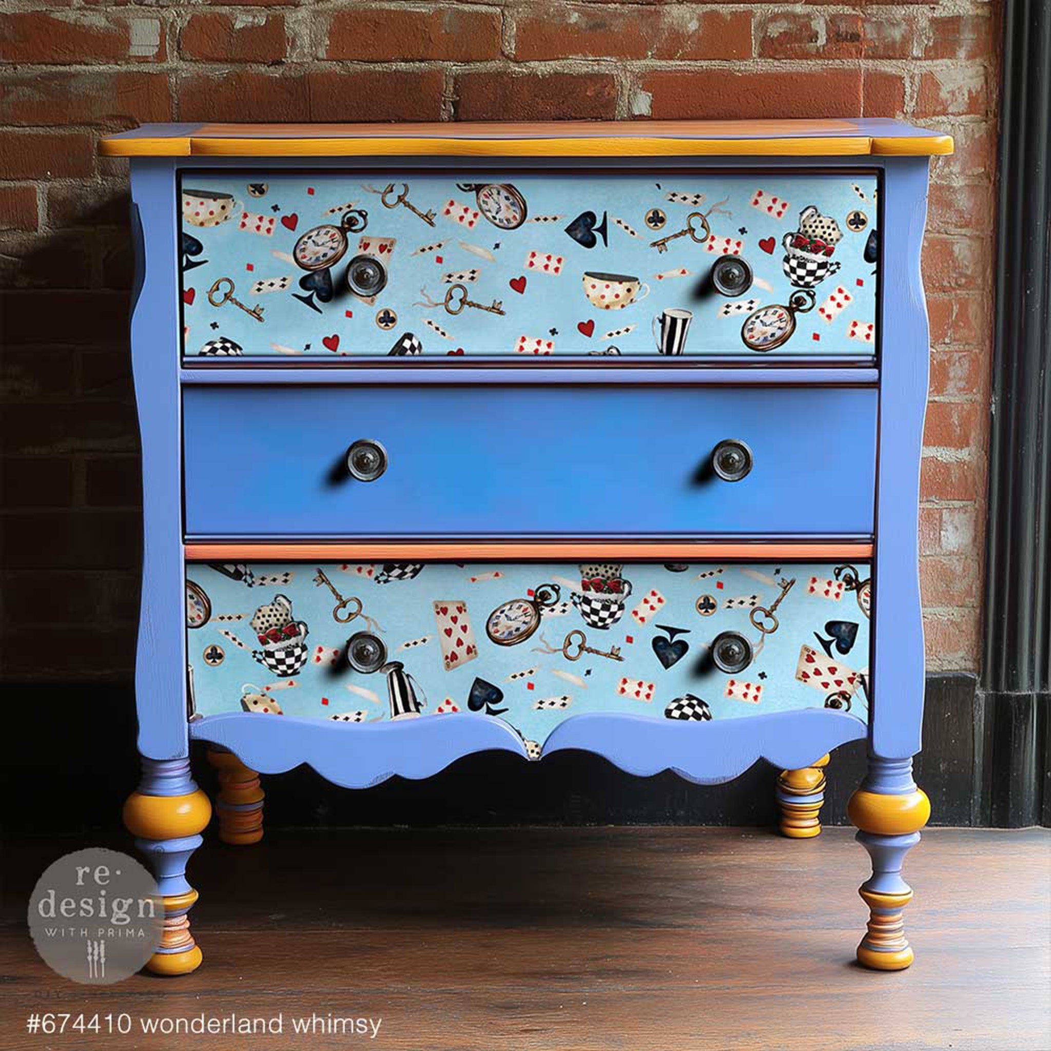 A vintage 3-drawer nightstand is painted sky blue with mustard yellow accents and features ReDesign with Prima's Wonderland Whimsy tissue paper on the top and bottom drawers.