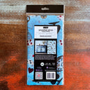 A package of ReDesign with Prima's Wonderland Whimsy tissue paper is against a dark wood background.