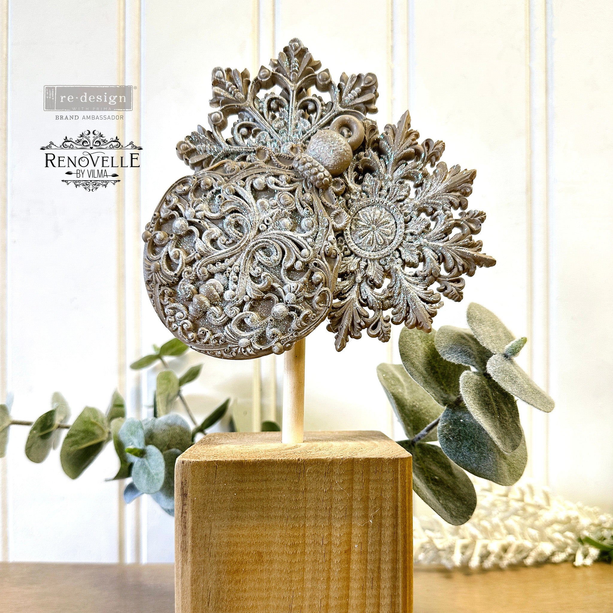 An ornament cluster created by Renovelle by Vilma using ReDesign with Prima's Wonder Gems silicone mould are painted beige with gold sparkles on them and are on a wooden dowel stuck into a cube of wood as a base.