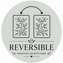 Circular reversible badge showing two paper sheets with matching mirrored botanical designs and arrows above, indicating the design can be used on both sides.
