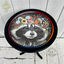 A round side table refurbished by TLC Vintages is painted black and features Belles & Whistles' Clever Raccoon rice decoupage paper on the top.