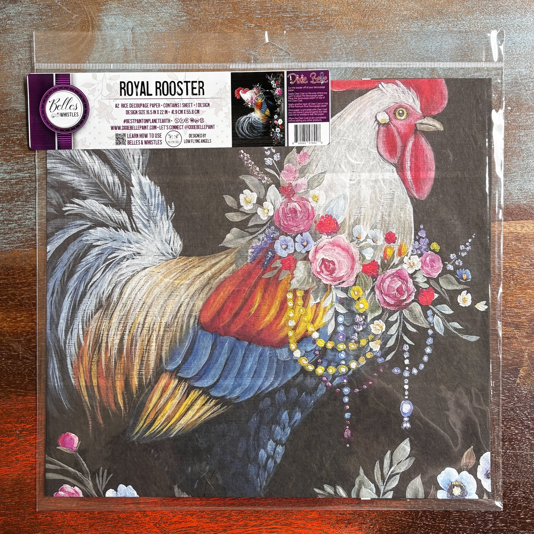 A package of Belles & Whistles' Royal Rooster A2 rice paper is against a dark wood background.