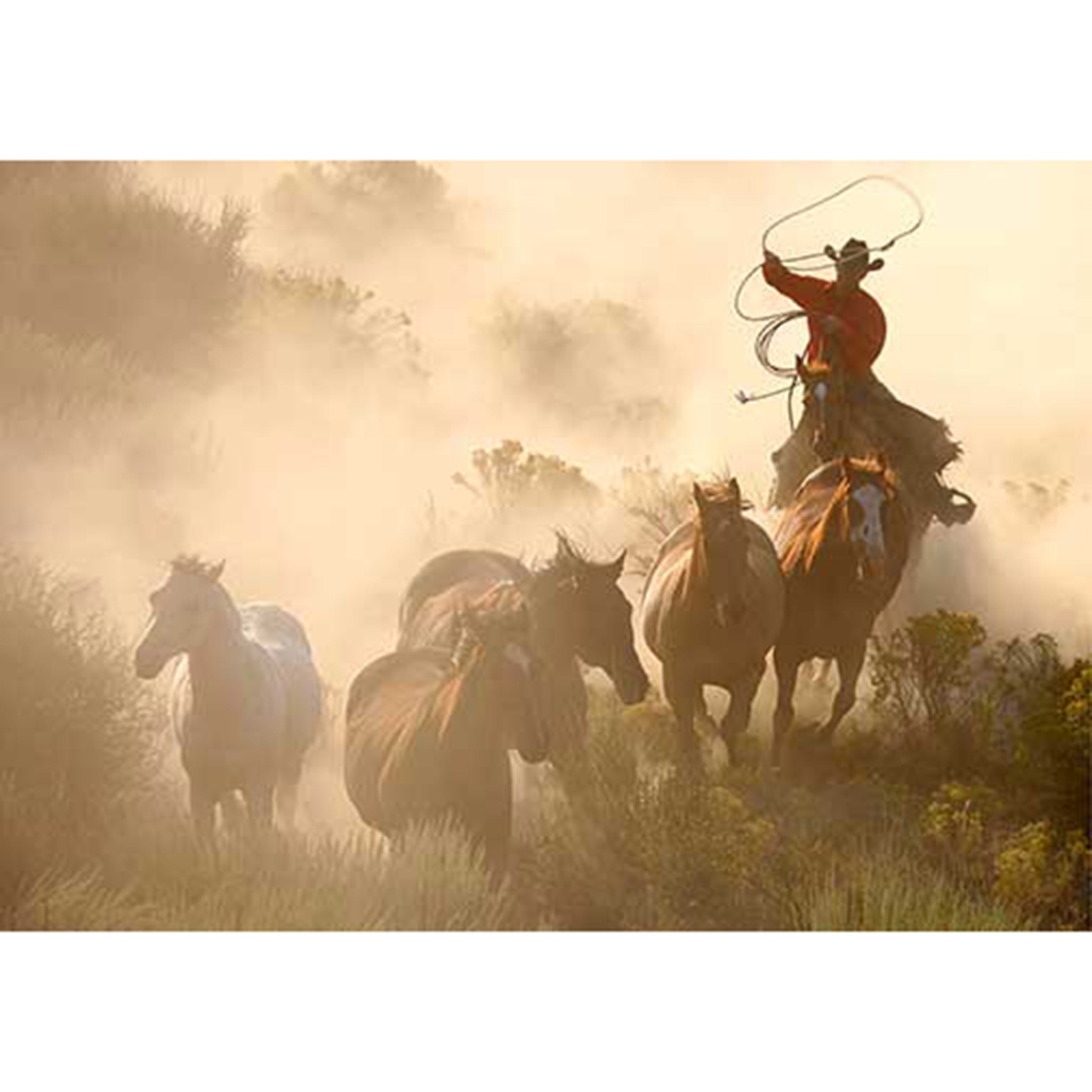 Rice paper design featuring a cowboy on horseback lassoing a herd of wild horses in a dusty landscape. White borders are on the top and bottom.