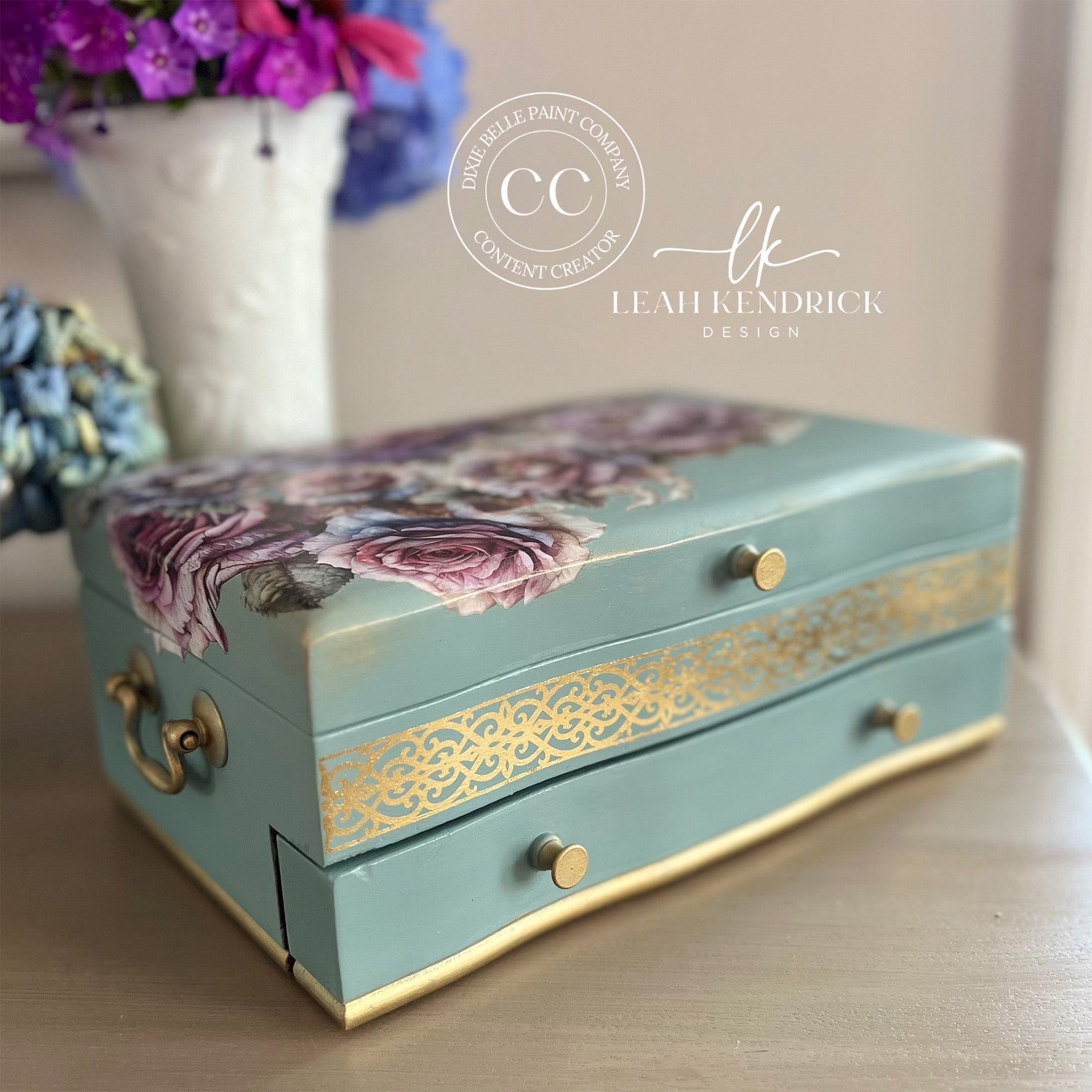 A small jewelry box refurbished by Leah Kendrick Design is painted muted teal with gold accents and features Belles & Whistles' Roses and Peonies small rub-on transfer on the top.